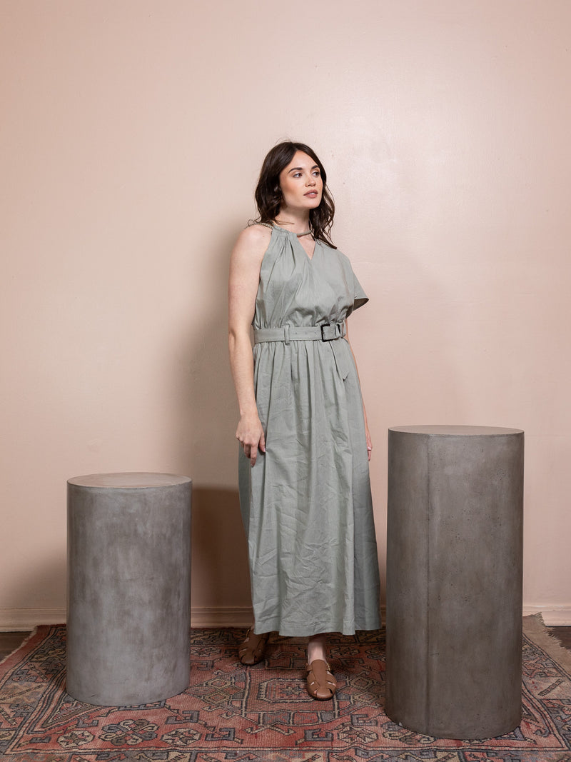 Woman in green dress against pink background