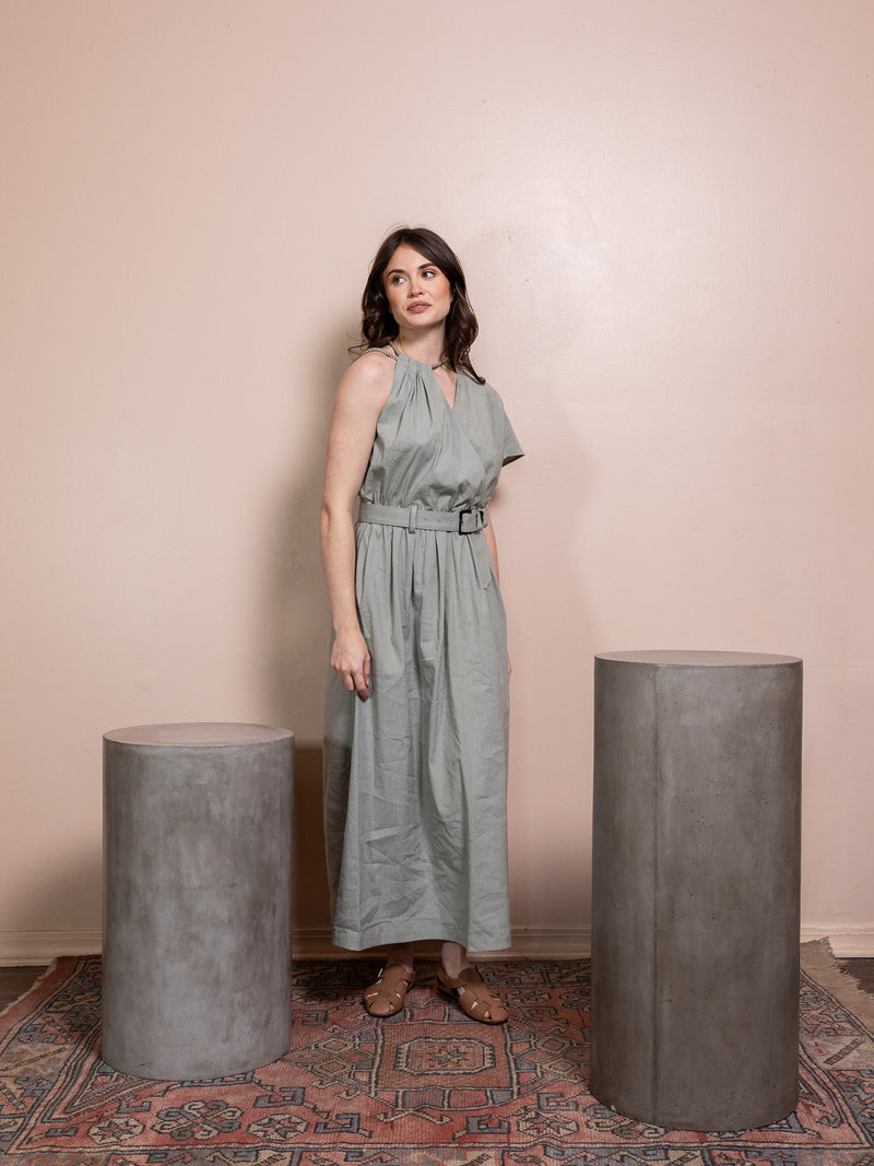 Woman in green dress against pink background