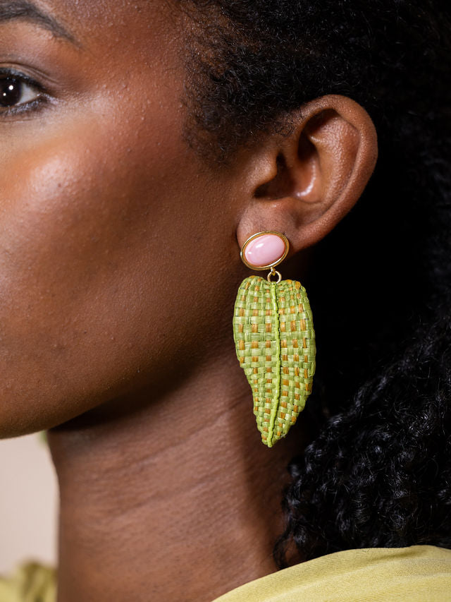 Woman wearing long earrings with woven leaves